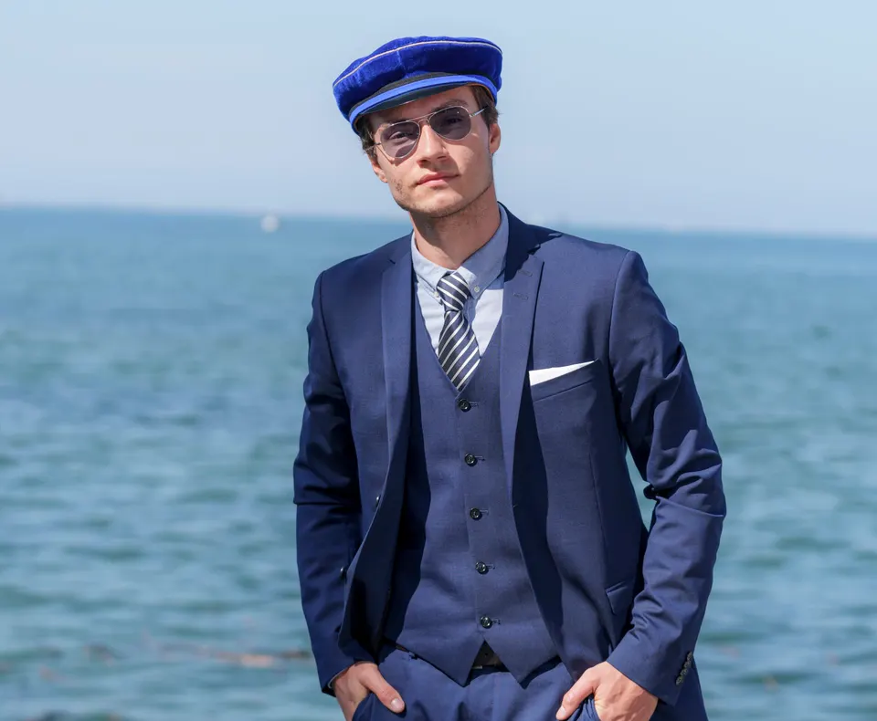 Maturant mit blauer Mütze am Seeufer