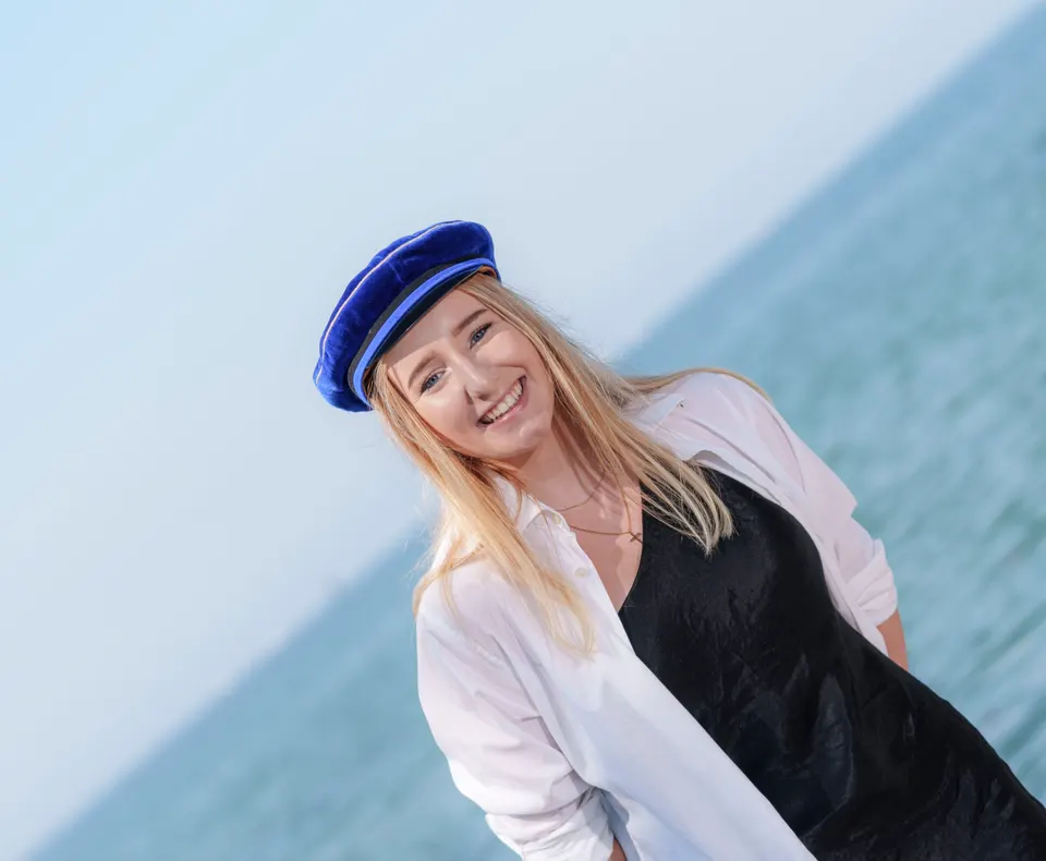 Maturantin mit blauer Mütze am Seeufer