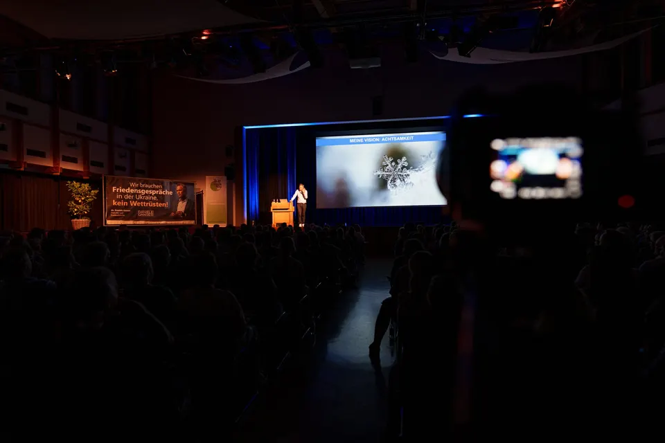 Dunkler Saal mit Bühne und Leinwand