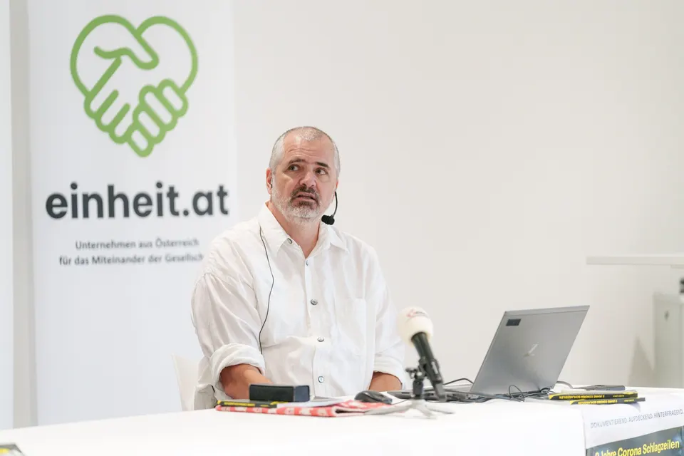 Redner am Pult bei einer Veranstaltung von einheit.at