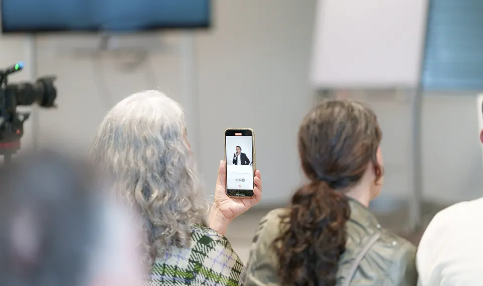 Zuschauerin fotografiert mit dem Handy