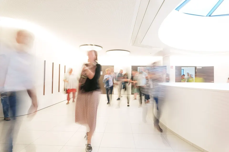 Menschen in Bewegung in einem hellen Foyer