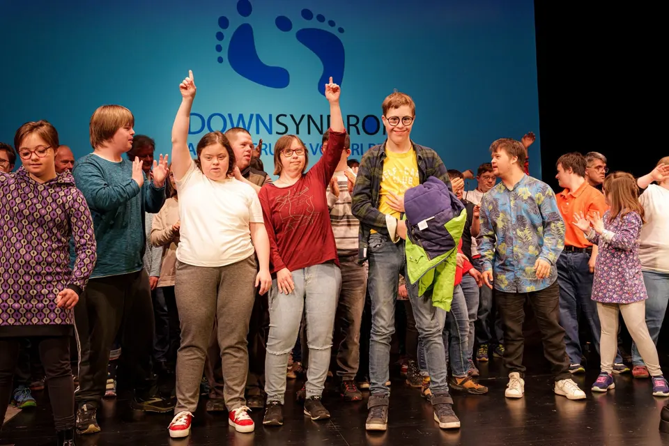 Gruppe auf der Bühne beim Welt-Down-Syndrom-Tag