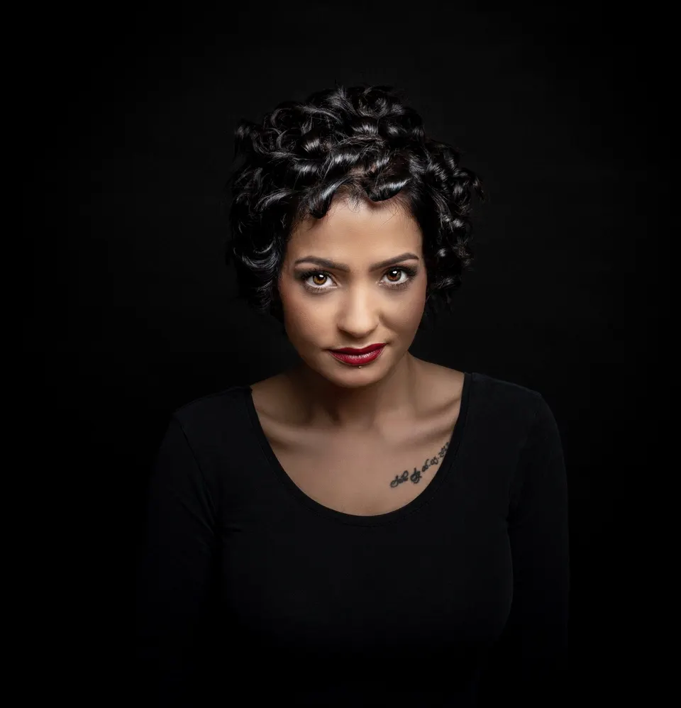 Frau mit Locken vor dunklem Grund