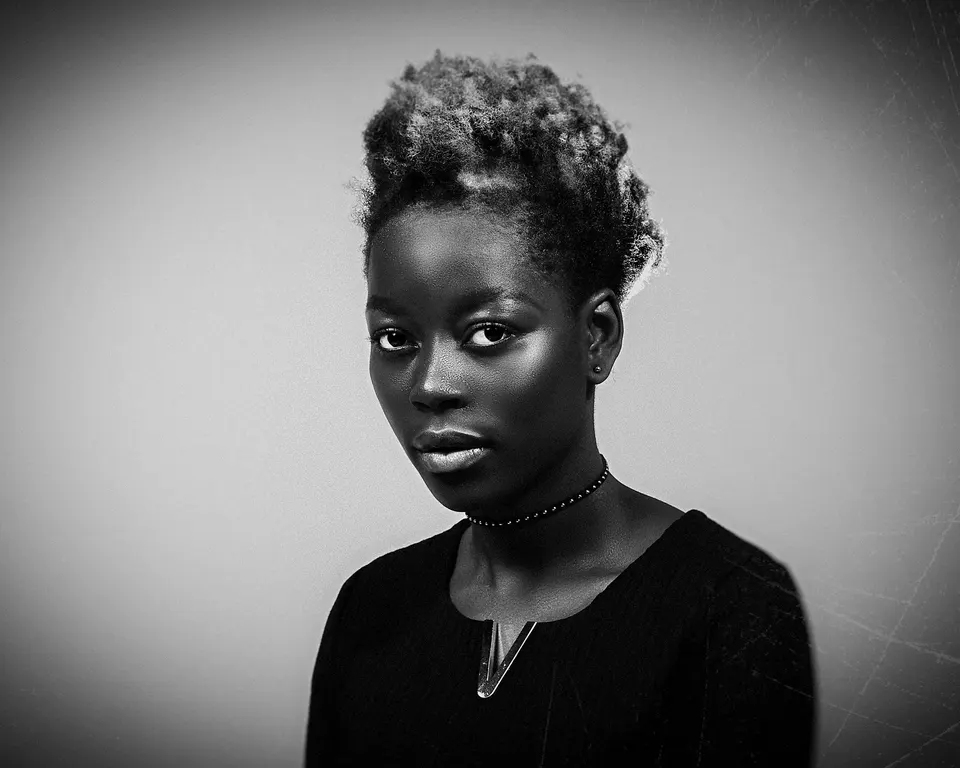 Frau mit kurzem Afro vor hellem Grund, schwarzweiß