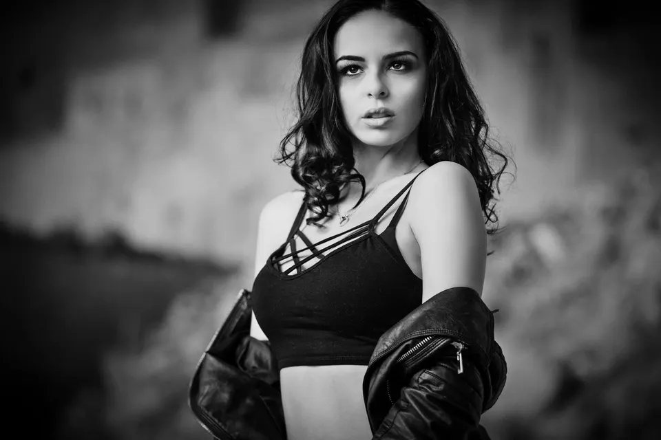 Frau mit Locken und Lederjacke im Freien, schwarzweiß