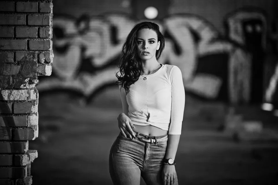 Frau vor einer Graffitiwand, schwarzweiß